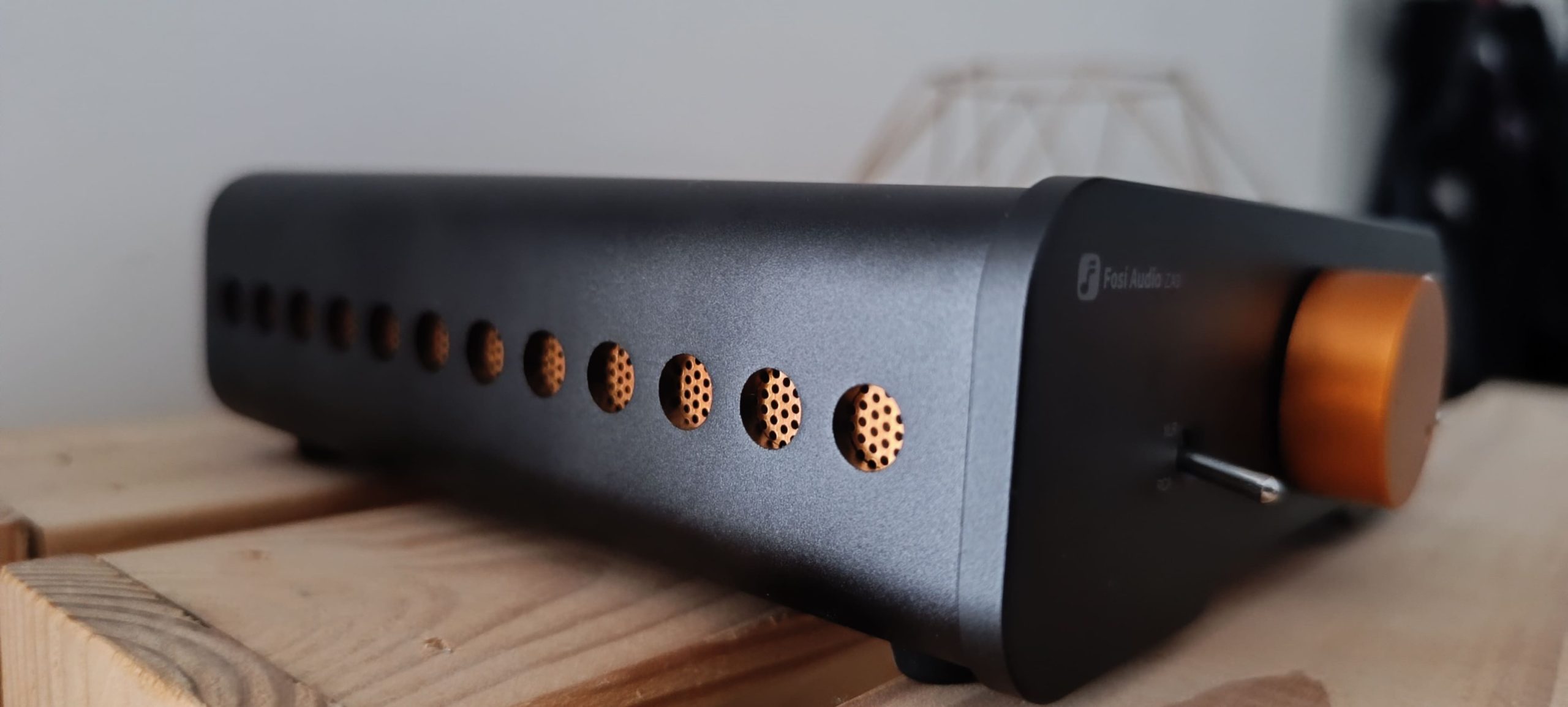 Fosi Audio ZA3 vue de côté — grilles d'aération aluminium anodisées orange et face avant avec bouton volume
