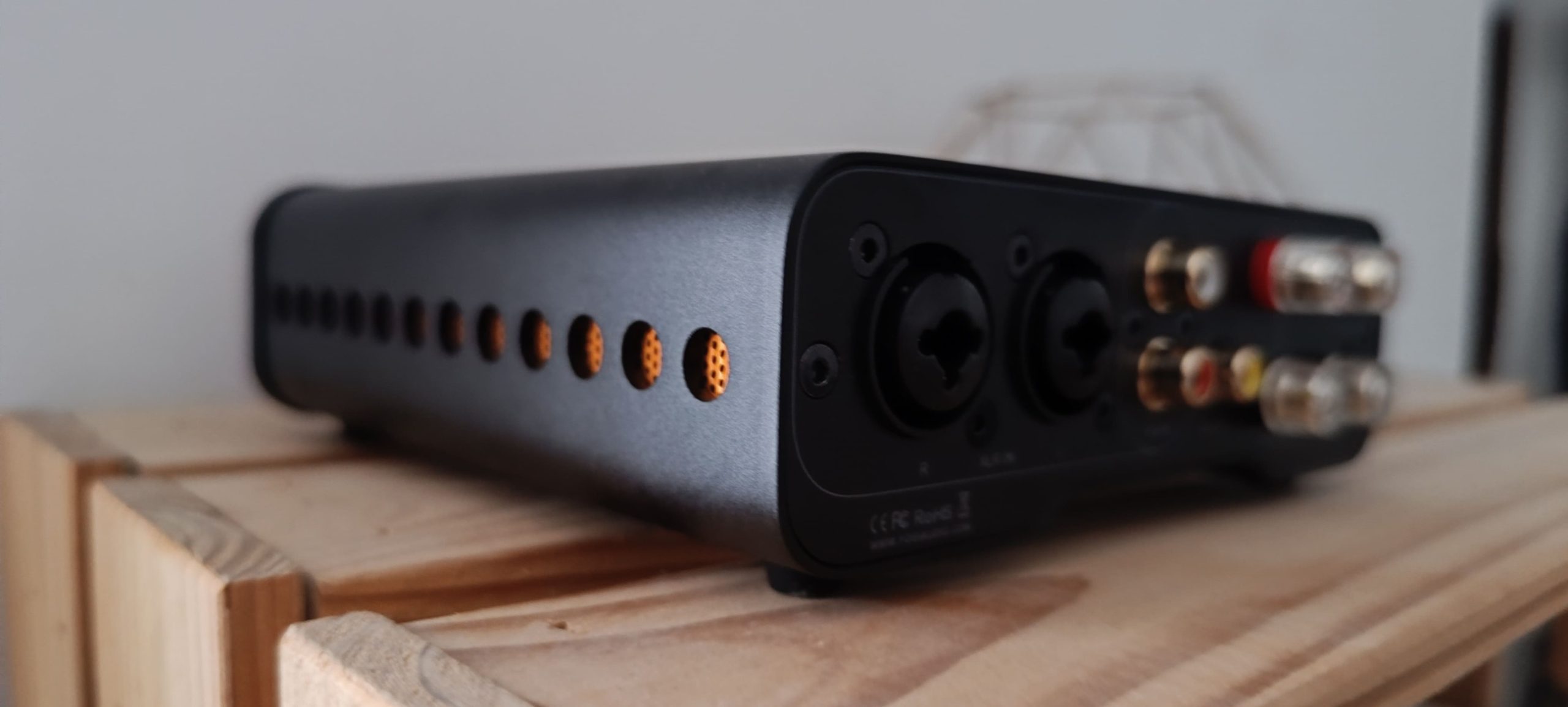 Fosi Audio ZA3 vue côté — grilles d'aération orange et connectique arrière, gabarit compact